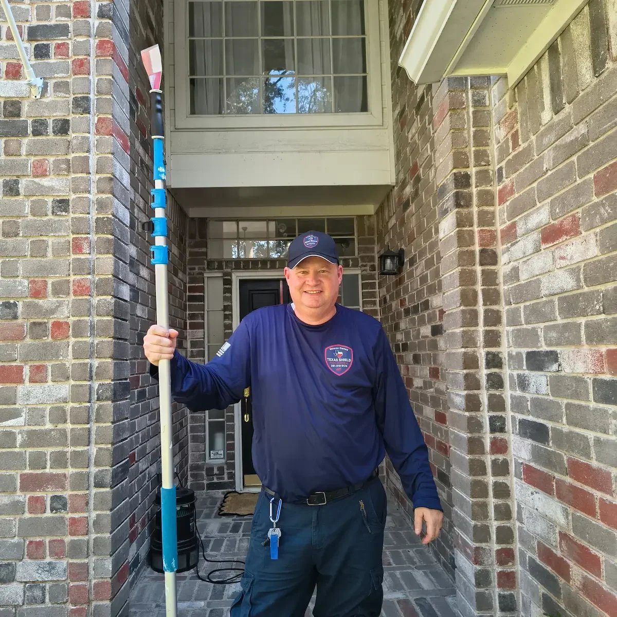 Sean, owner of Texas Shield Pest Control, in uniform in front of a Fort Bend home