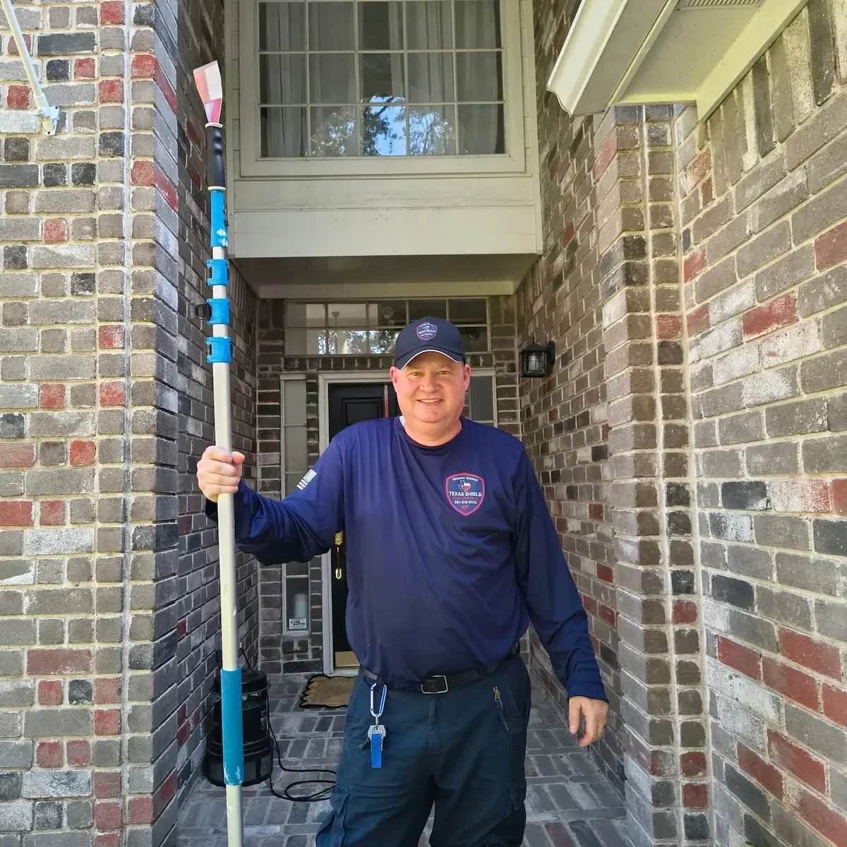 Sean, owner of Texas Shield Pest Control, in uniform in front of a Fort Bend home